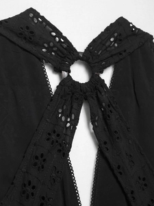 Detailed macro view of black eyelet embroidery fabric and elegant metal ring connector