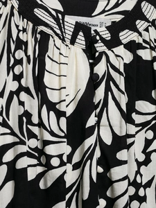 Detail of the stand collar and fabric buttons on the black and white floral print top