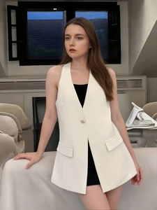 Detail of white sleeveless vest featuring tailored lapels and a single textured button