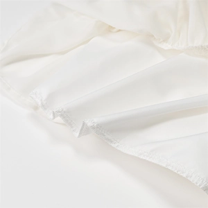 Détail rapproché montrant les coutures de surjet sur le tissu de la robe d'été blanche