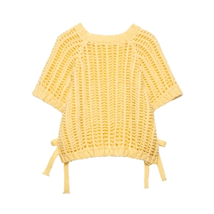 Détail du haut en tricot jaune clair avec texture ajourée et cordons de serrage latéraux