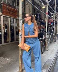 Outdoor shot of a women's blue washed denim vest and high-waist wide-leg pants