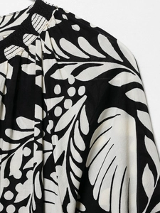 Detail of floral printed top featuring a stand-up collar and delicate shirring technique