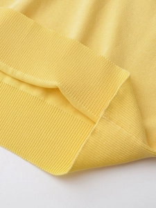 Detail shot of bright yellow knit polo shirt showing premium ribbed cuffs and soft texture