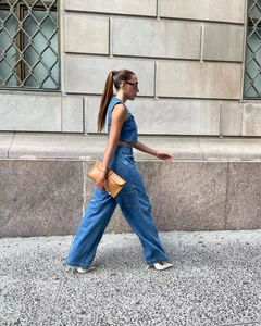 Street style shot of a blue denim vest and wide-leg cargo pants with large side pockets