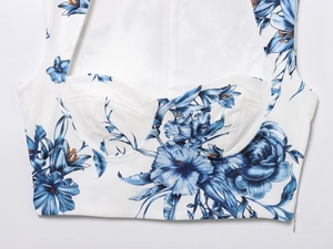 Detail of structured bra cups and blue floral print on a white cropped summer top