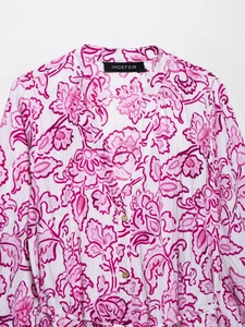 Close-up of floral print V-neck dress with wood buttons and textured white fabric