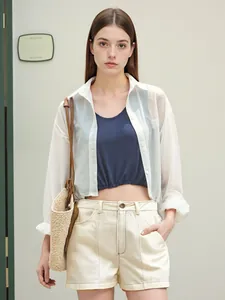 Détail du short beige taille haute avec surpiqûres noires et haut court assorti