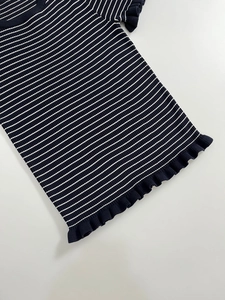 Détail de l'ourlet à volants délicats et de la texture en maille rayée du haut pour femme