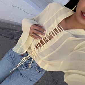Pale yellow sheer long sleeve top with chic lace-up front detail and trendy cut-out design