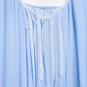 Light blue summer dress featuring intricate white lace trim and vertical pleated details