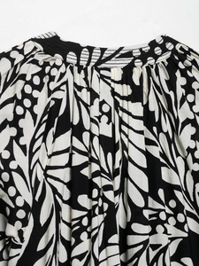 Close-up of elegant black and white floral print with delicate pleated collar details
