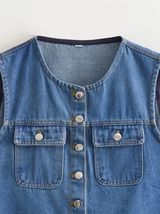 Detail of blue denim vest with silver buttons, yellow stitching and front flap pockets