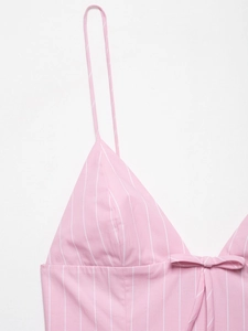 Close-up of pink and white striped dress featuring thin straps and a bow detail