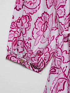 Detailed view of elasticated sleeve cuff with wooden button and pink floral pattern print