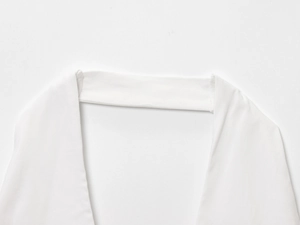 Detailed view of the halter neck design and smooth cotton fabric on this white summer top