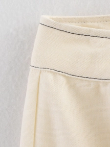 Détail macro du tissu texturé crème avec des doubles coutures contrastées gris foncé