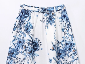 Close-up of blue floral print pattern on a white midi skirt with matching belt detail