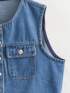 Detailed macro view of classic blue denim vest featuring metal buttons and orange stitching