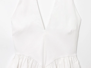 Detailed view of the deep V-neckline and pleated waist of the white summer halter top
