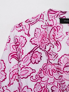 Detailed close-up of V-neckline with floral print and crinkle texture fabric on dress