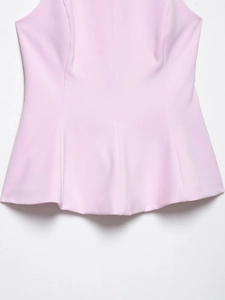 Detail of light pink peplum top showing delicate fabric texture and neat stitching seam