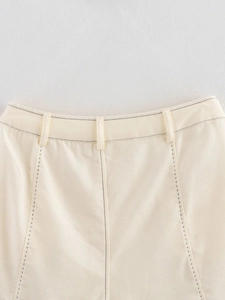 Gros plan du short en jean crème avec surpiqûres noires contrastées et passants de ceinture