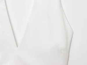 Macro shot of V-neckline stitching on a minimalist white backless halter balloon top