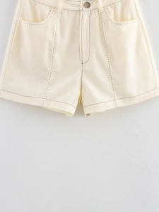 Vue détaillée du short taille haute crème avec coutures contrastées et bouton vintage
