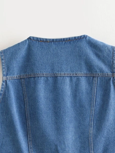 Detail of blue denim vest showing contrast stitching and textured twill fabric