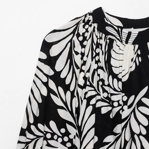 Floral print top with a mandarin collar and detailed white leaf patterns on black fabric