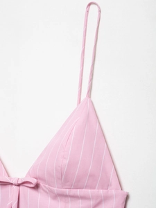 Detail of pink striped camisole dress with spaghetti straps and a decorative bow tie