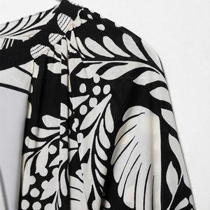 Floral print top with stand collar and pleated details in black and white tropical leaves