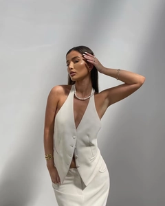 Detailed view of cream v-neck halter top with matching fabric-covered buttons and collar