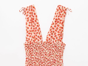 Detail view of floral v-neck mini dress showing smocking craft and shoulder tie straps