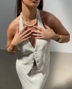Detail of V-neck halter top with pearl necklace and minimalist metal jewelry set