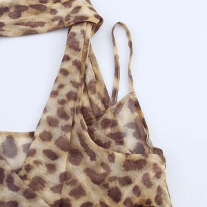 Detail of leopard print mesh bodysuit featuring thin straps and criss-cross front design