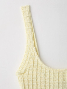 Detailed macro view of cream knit waffle texture fabric on elegant sleeveless dress