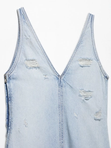 Nahaufnahme von hellblauem Jeanskleid mit V-Ausschnitt und modischen Rissen