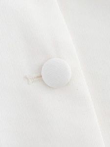 Detail macro shot of white twill fabric texture and matching fabric-covered button