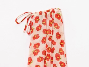 Detail of red floral chiffon fabric with side drawstring on the white mini dress