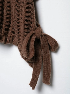 Détail de maille épaisse marron foncé avec tissage ajouré et cordon de serrage décoratif