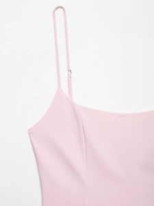 Detail of adjustable metal buckle on pink spaghetti straps of the summer dress