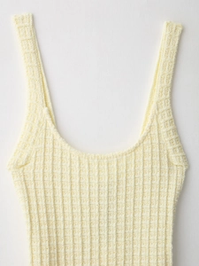 Detail of soft cream knitted fabric with vertical ribbing on an elegant summer dress