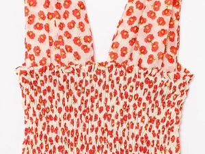 Detailed macro view of summer floral dress with red poppies and smocked waist elastic fabric