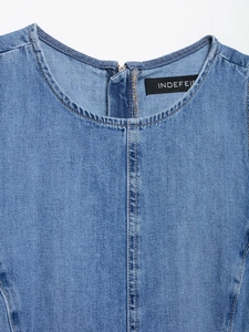 Detail of round neckline and back zipper on light blue washed denim dress