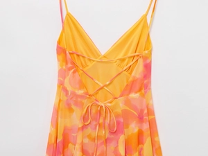 Detail of backless floral dress with thin criss-cross tie-up straps and vibrant summer print