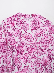 Detail of V-neckline on summer dress with pink floral patterns on breathable fabric