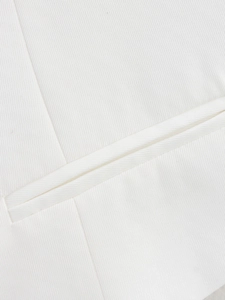 Detail of white V-neck top showing twill fabric texture and precise welt pocket stitching