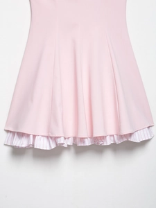 Detail view of pink dress hem with white and red striped pleated layered ruffles